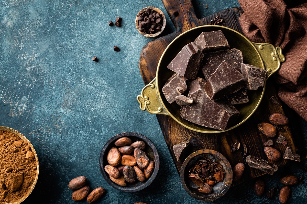 Un bol în care se află mai multe cuburi de ciocolată neagră, o comoară pentru sănătatea organismului