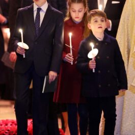 Prințul George, Prințesa Charlotte și Prințul Louis în timp ce țin în mână câte o lumânare la concertul de colinde de Cărciun