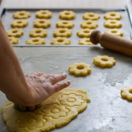 Femeie decupând biscuiți italieni din aluat fraged