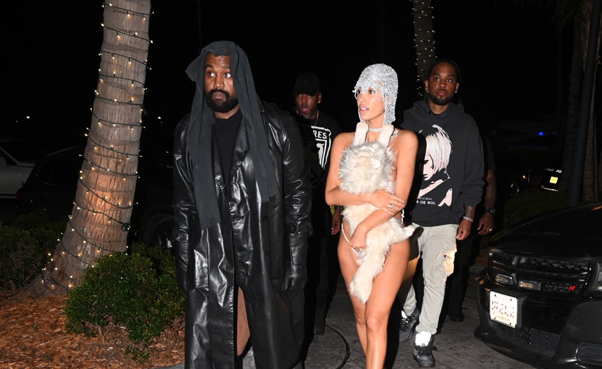 Kanye West într-o ținută all black și Bianca Censori în costum de baie cu o pisică de pluș