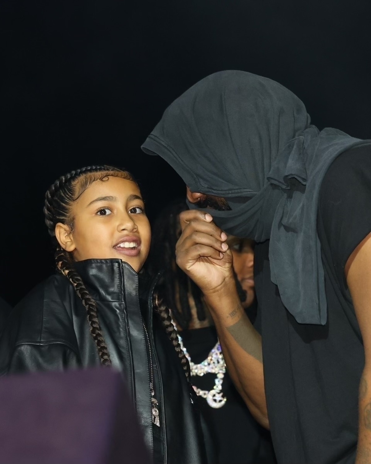 Kanye West în timp ce vorbește cu North West la concert