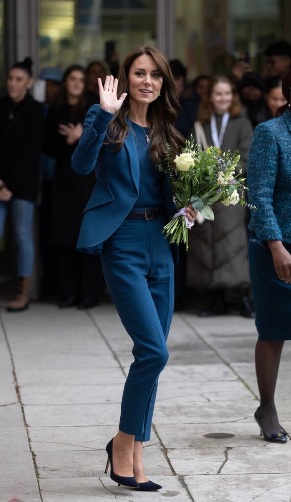 Kate Middleton, într-un costum albastru, cu un buchet mare de flori în mână