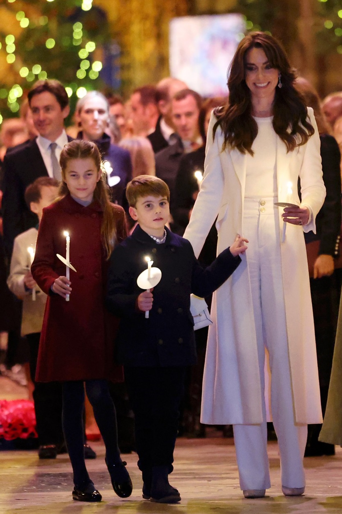 Kate Middleton în timp ce îl ține de mână pe Prințul Louis, alături de care se află Prințesa Charlotte, la concertul de colinde de Crăciun