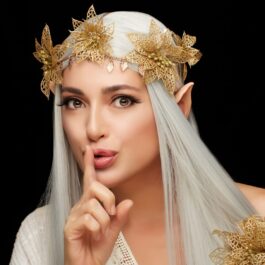 O femeie frumoasă care are părul alb și ține degetul în dreptul gurii pentur a sugera faptul că este zodia care află că este iubită în secret în anul 2024