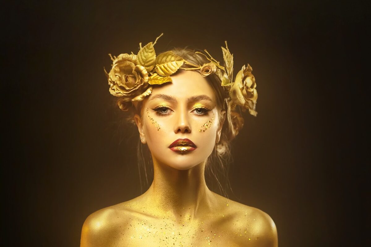 O femeie frumoasă care este acoperită cu auriu pentru a reprezenta zodia care va suferi cel mai mult anul acesta