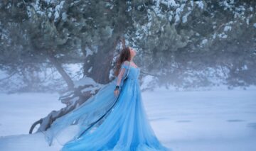 O femeie frumoasă care poartă o rochie albastră și ilustrează zodia nefericită a lunii decembrie 2023