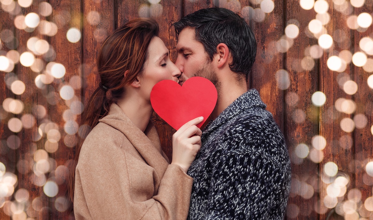 o femeie și un bărbat care se sărută în spatele unei inimioare pentru a reprezenta una dintre cele trei zodii care au noroc în dragoste pe 11 decembrie 2023