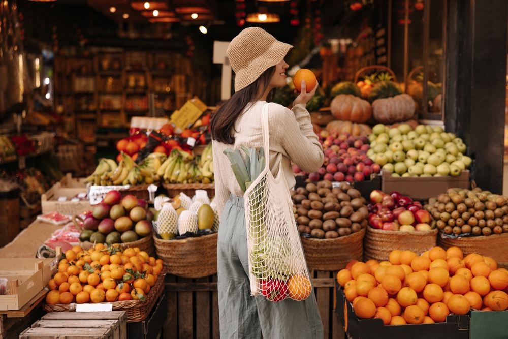 O femeie care se află într-o piață de legume și fructe