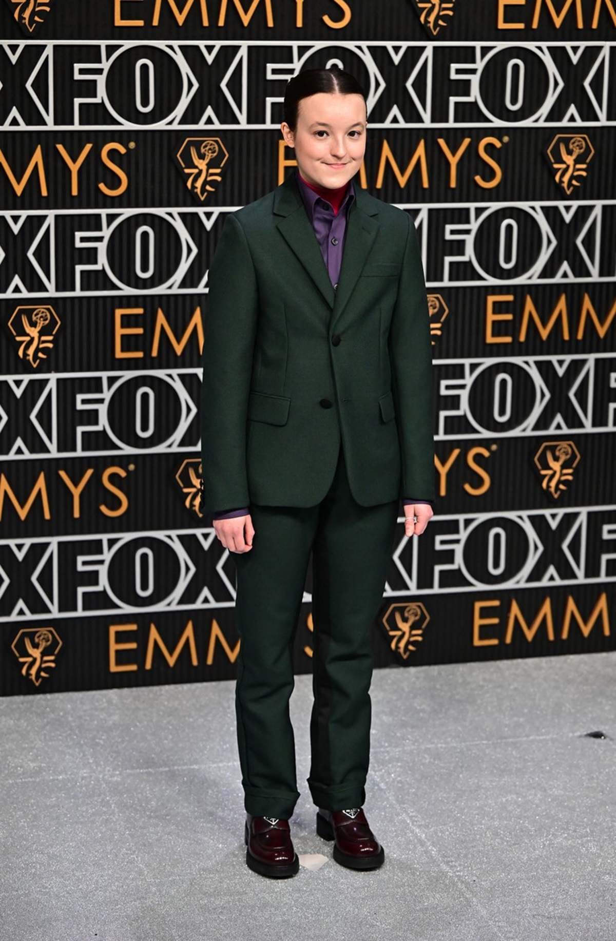 Bella Ramsey într-un costum elegant verde pe covorul roșu de la Premiile Emmy 2023