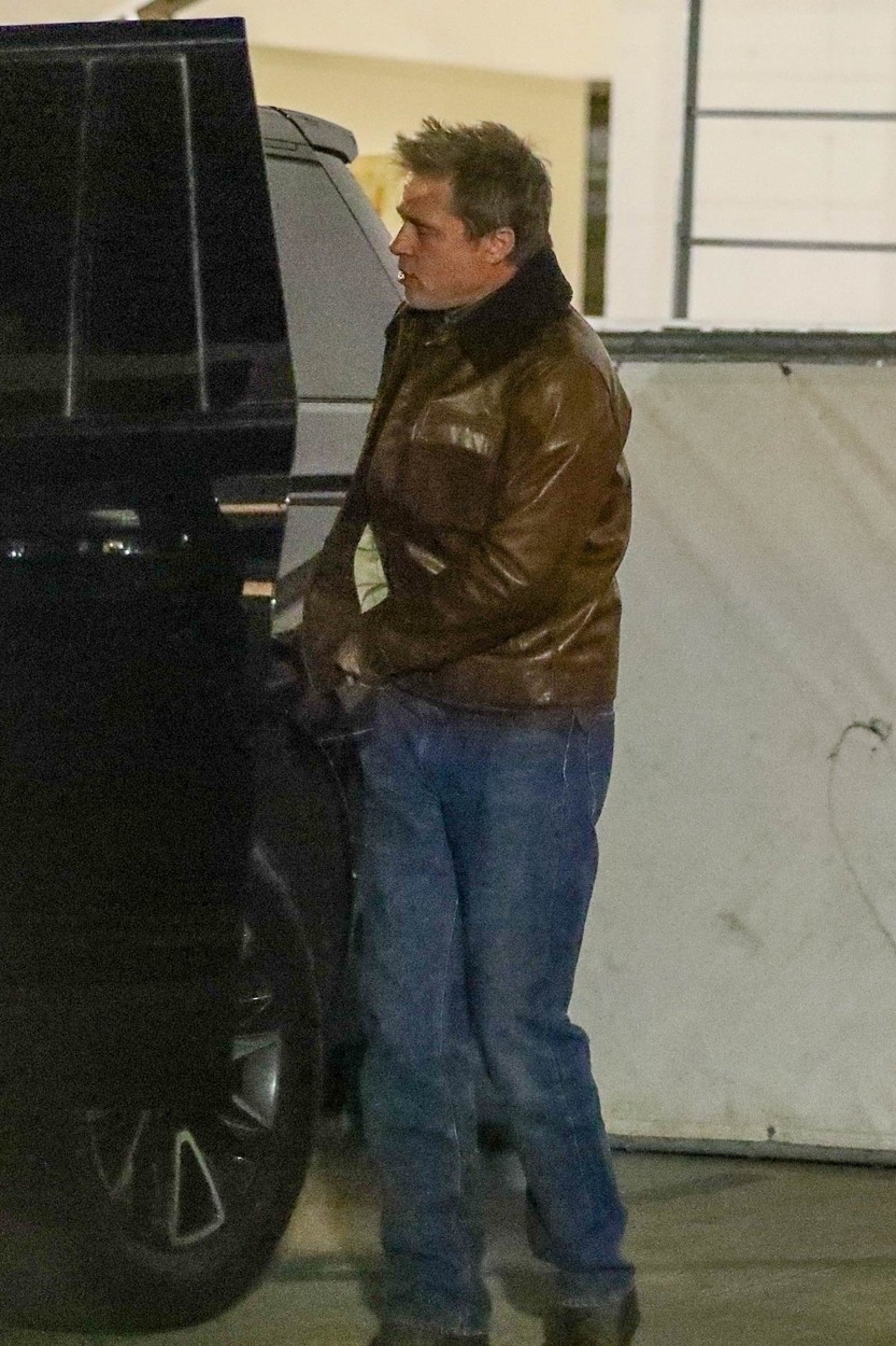 Brad Pitt, într-o geacă din piele și o pereche de jeanși, în parcare