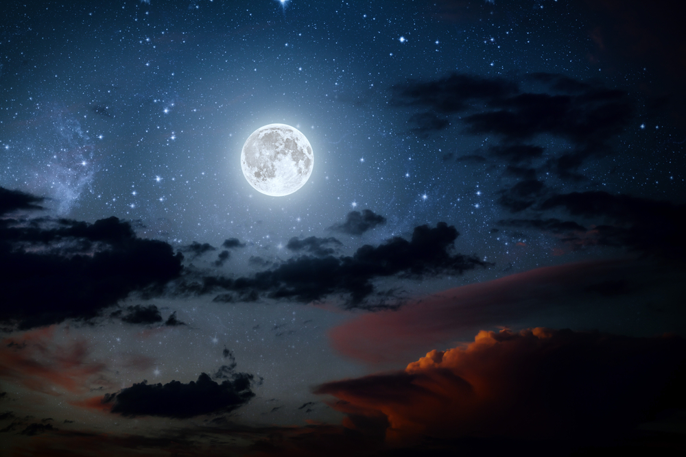 Fază a lunii pe un cer întunecat cu nori luminat doar de lună