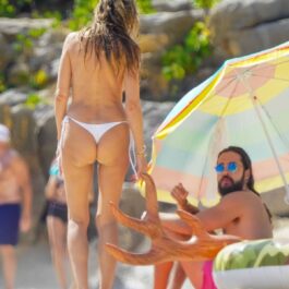 Heidi Klum, fără sutien, pozată din spate în timp ce vorbește cu soțul ei, Tom Kaulitz