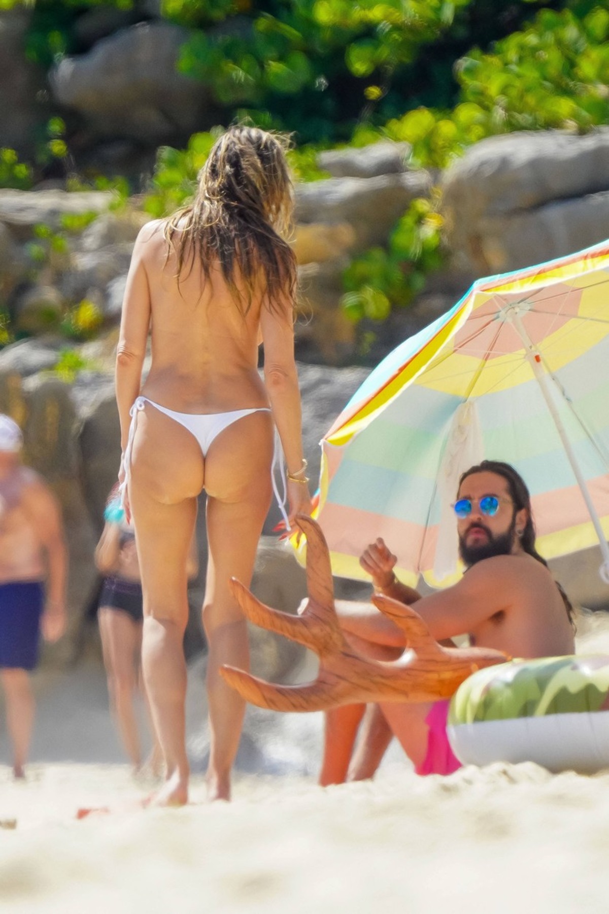 Heidi Klum, fără sutien, pozată din spate în timp ce vorbește cu soțul ei, Tom Kaulitz