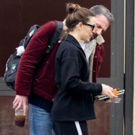 Ben Affleck care se apleacă asupra unei agende pe care o ține în mână Jennifer Garner