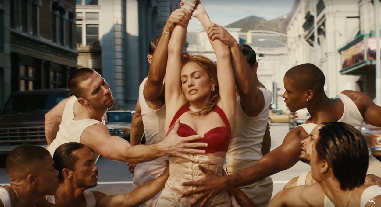 Jennifer Lopez înconjurată de mai mulți dansatori în videoclipul piesei Can't Get Enough