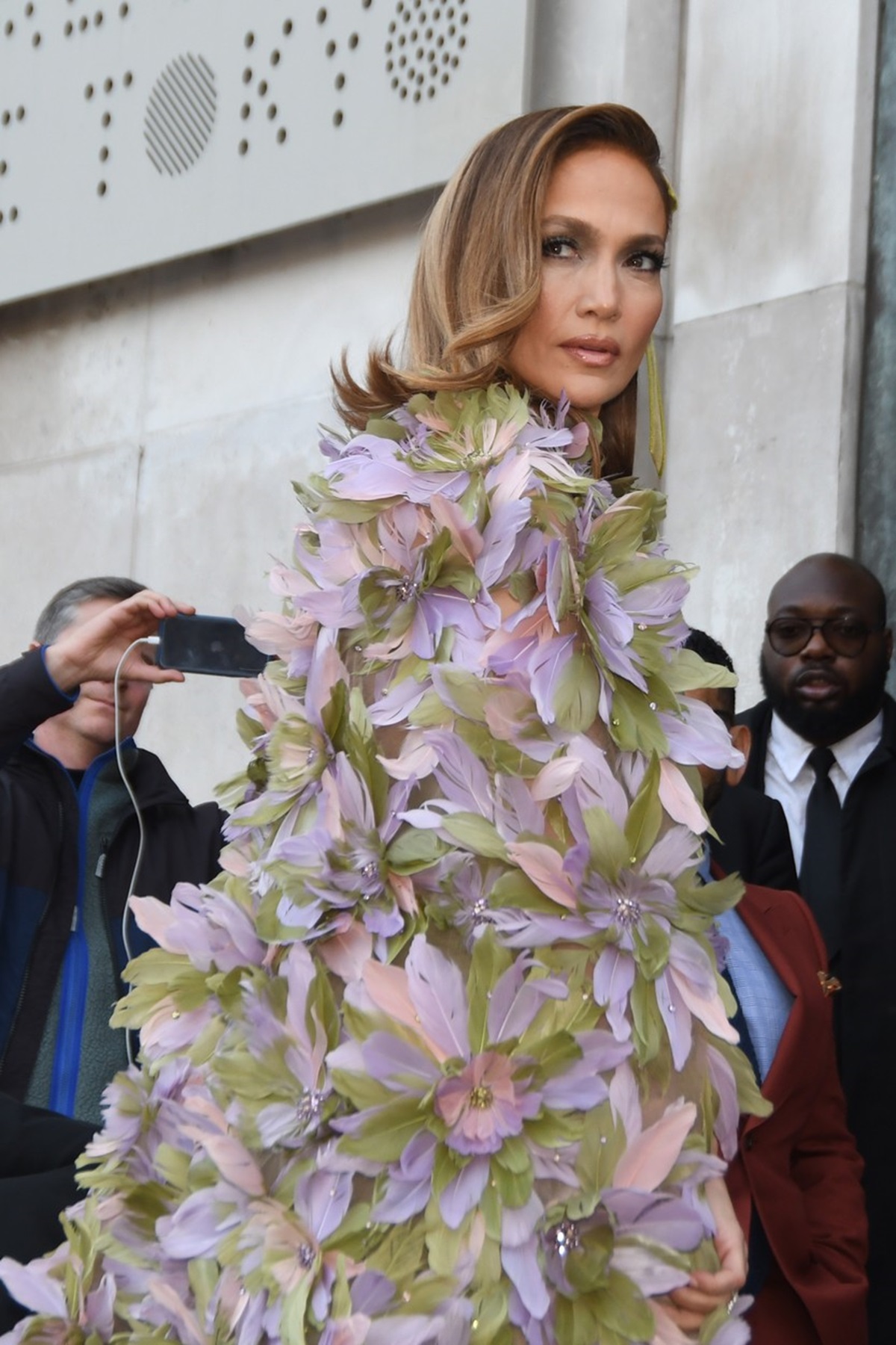 Jennifer Lopez purtând o rochie cu capă decorată cu flori la Săptămâna Modei de la Paris 2024
