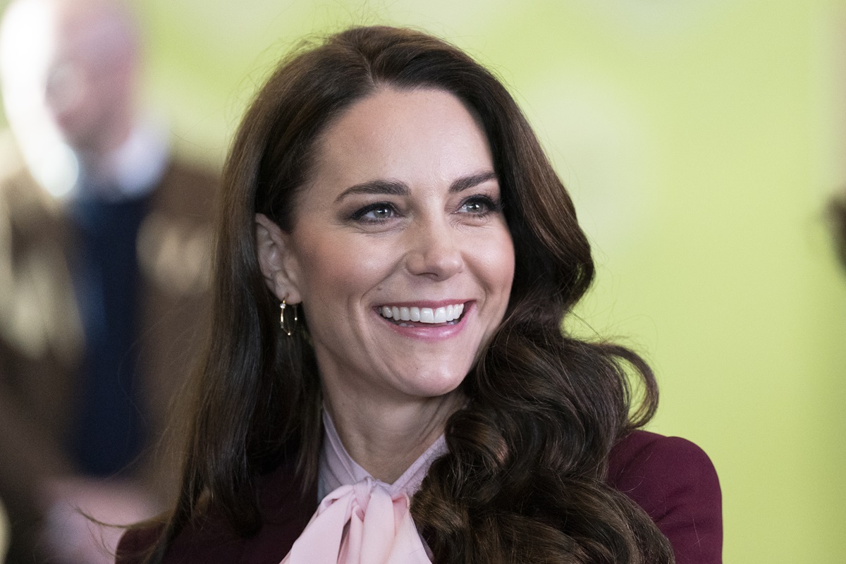 Kate Middleton într-o bluză elegantă în timp ce zâmbește la cameră