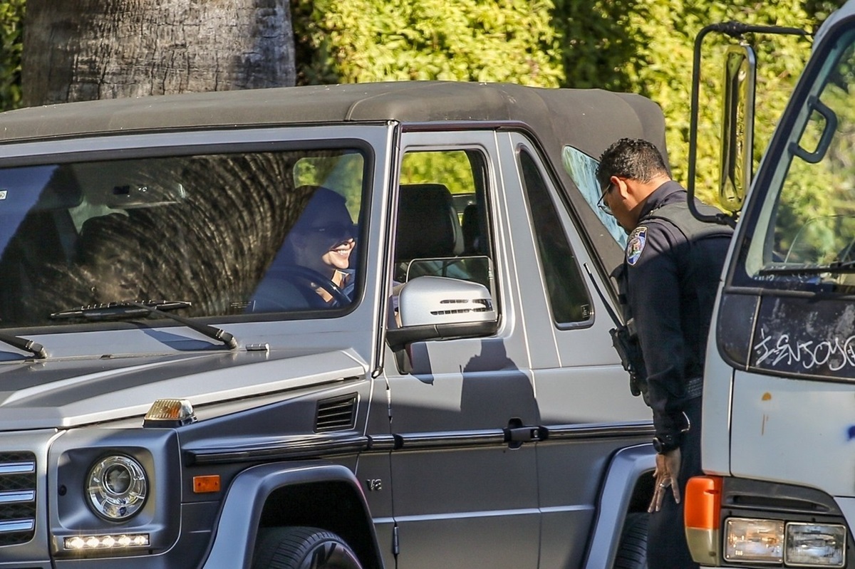 Kendall Jenner și Hailey Bieber într-o mașină în timp ce primesc amendă de la un polițist