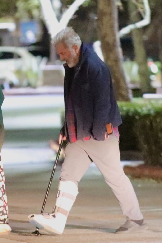 Mel Gibson în timp ce se plimbă în cârjă pe stradă