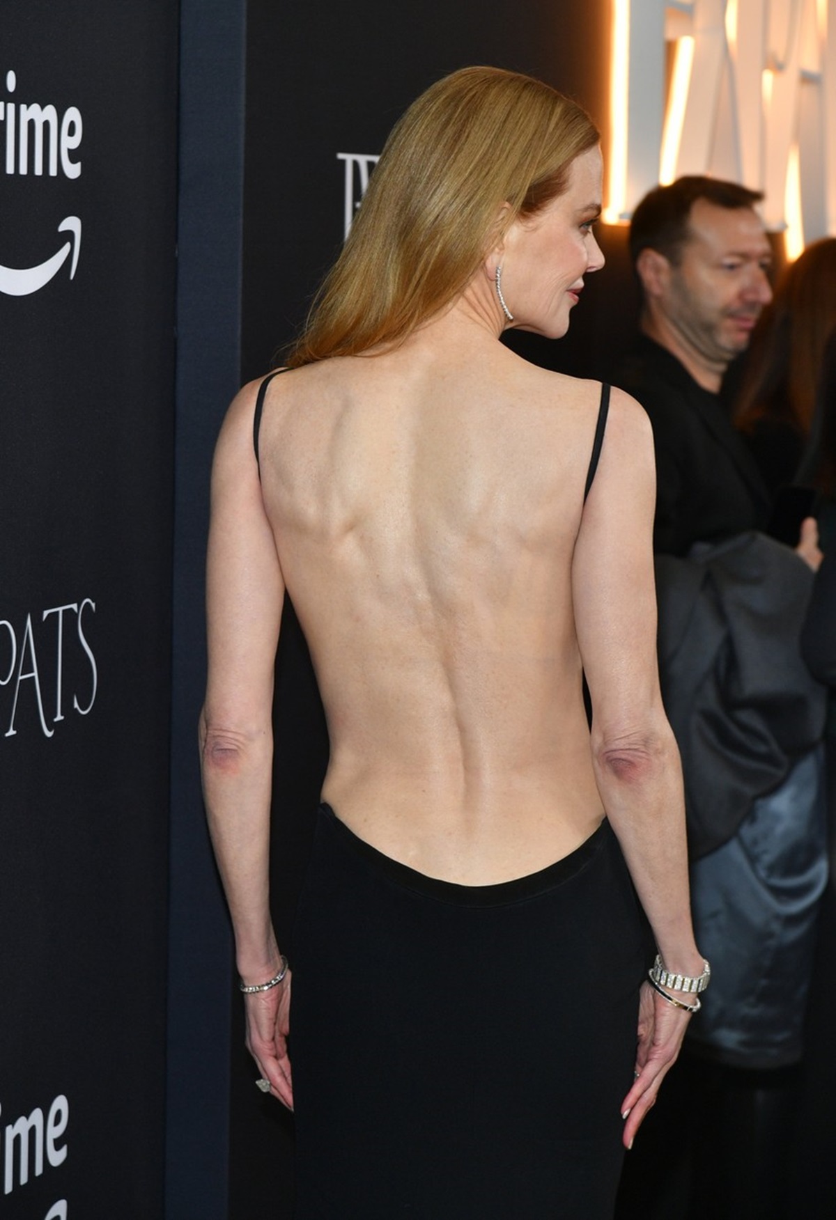 Nicole Kidman fotografiată cu spatele într-o rochie neagră la premiera Expats