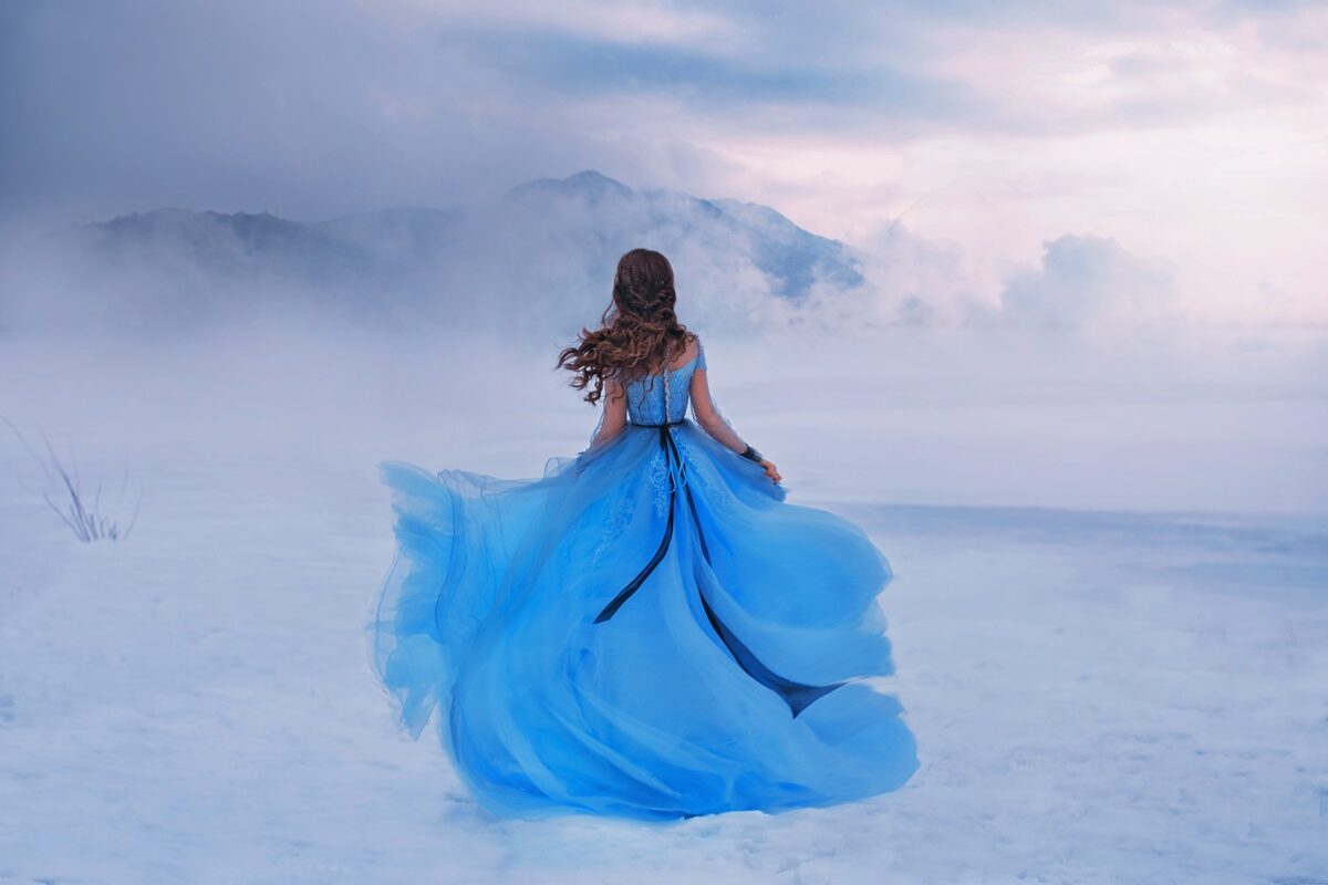 O femeie frumoasă într-o rochie albastră care ilustrează zodia nefericită a lunii februarie 2024