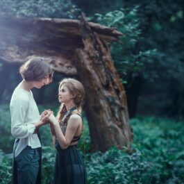 Un cuplu tânăr care se ține în brațe într-o pădure și ilustrează acele zodii care au noroc în dragoste în luna februarie 2024