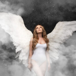 O femeie într-un body alb. cu aripi de înger în spate
