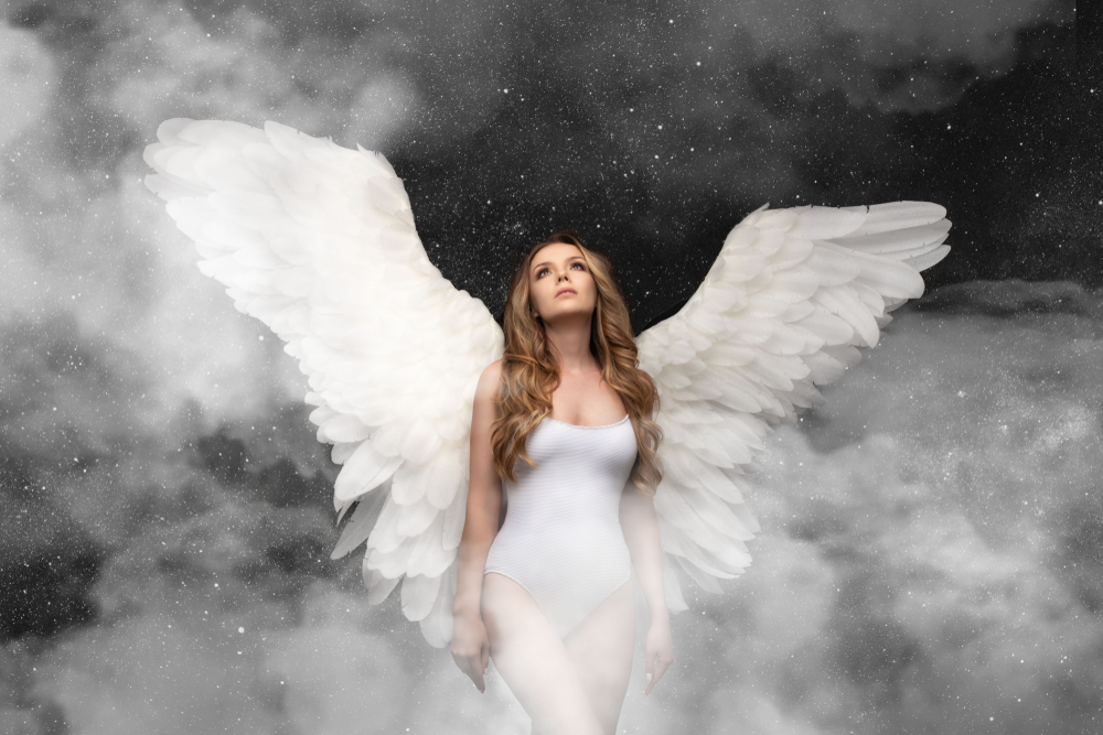 O femeie într-un body alb. cu aripi de înger în spate