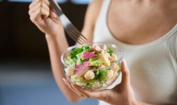 O femeie care mănâncă salată dintr-un castron