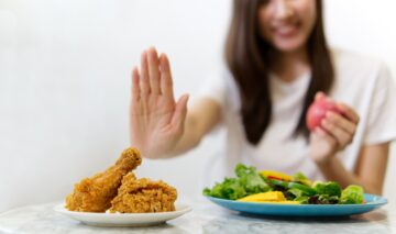 O femeie care evită să consume alimentele care cresc coleterolul și alege o salată verde
