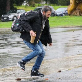 Ben Affleck încearcă să traverseze o stradă inundată