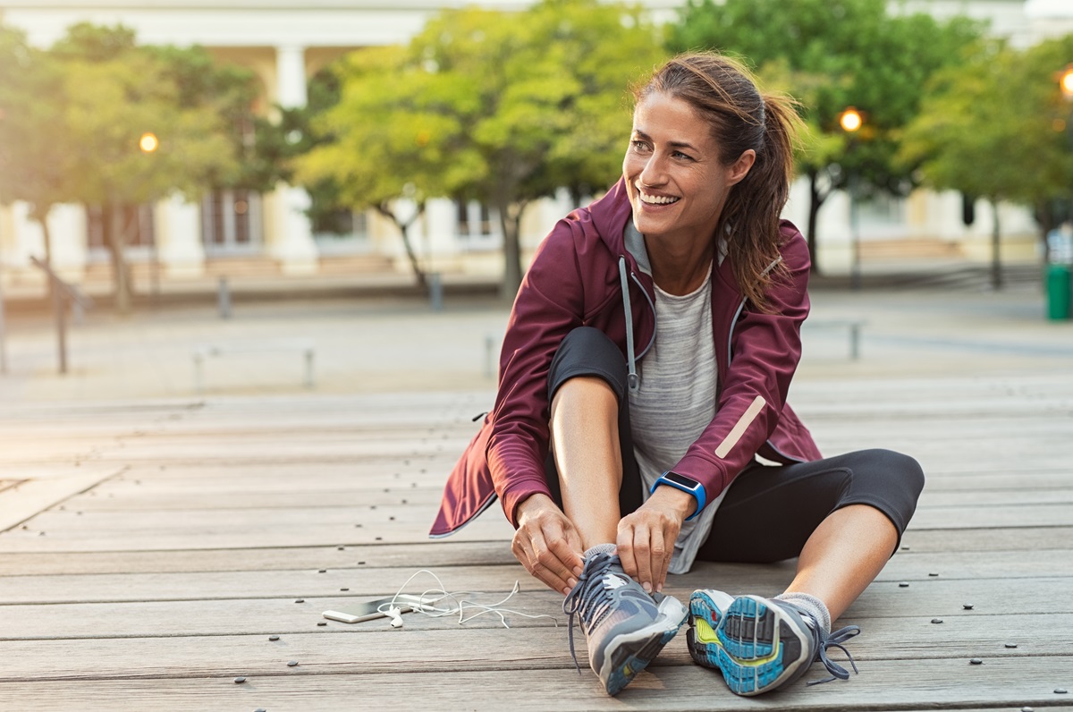 O femeie care stă pe jos după ce a fost la alergat pentru a ilustra câte calorii poți arde atunci când alergi