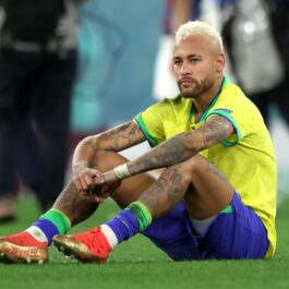 Neymar în timp ce stă pe terenul de fotbal, în echipament, după ce a pierdut un meci de fotbal