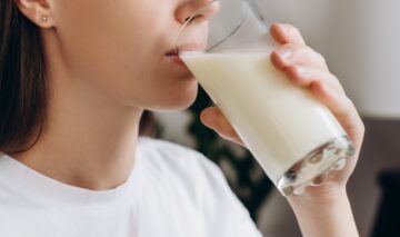 O femeie care bea lapte dintr-un pahar