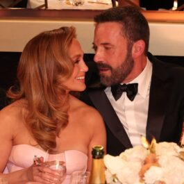 Jennifer Lopez și Ben Affleck în timp ce discută la o masă la Golden Globes 2024