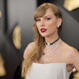 Taylor Swift în timp ce pozează pe covorul roșu de la Premiile Grammy 2024