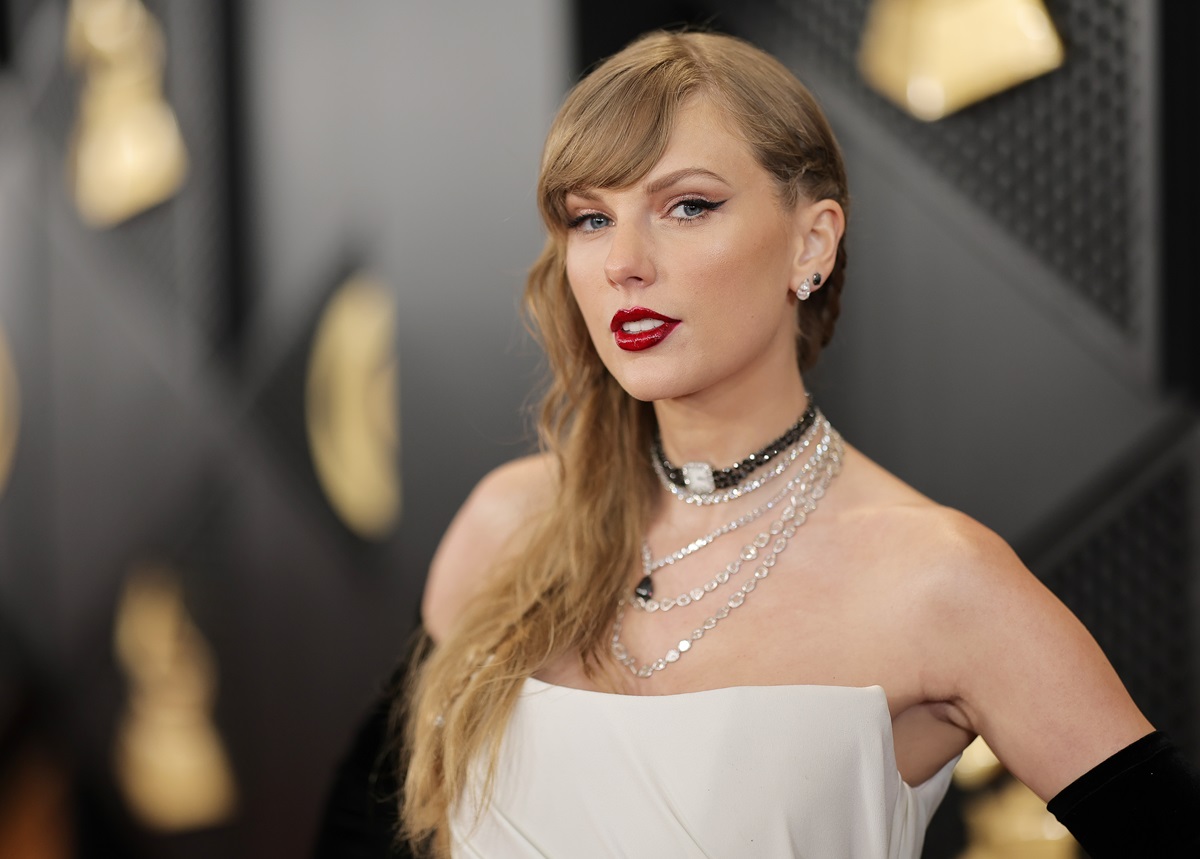 Taylor Swift în timp ce pozează pe covorul roșu de la Premiile Grammy 2024