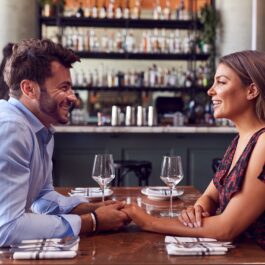 Un cuplu de îndrăgostiți care stau la o masă și își pun întrebări la prima întâlnire