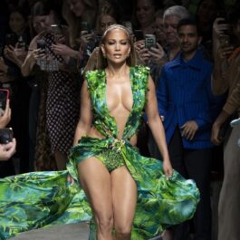 Jennifer Lopez în timp ce defilează într-o rocie verde, Versace, în anul 2019