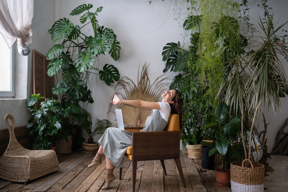 O femeie frumoasă care stă pe un scaun și este înconjurată de plante cu proprietăți vindecătoare