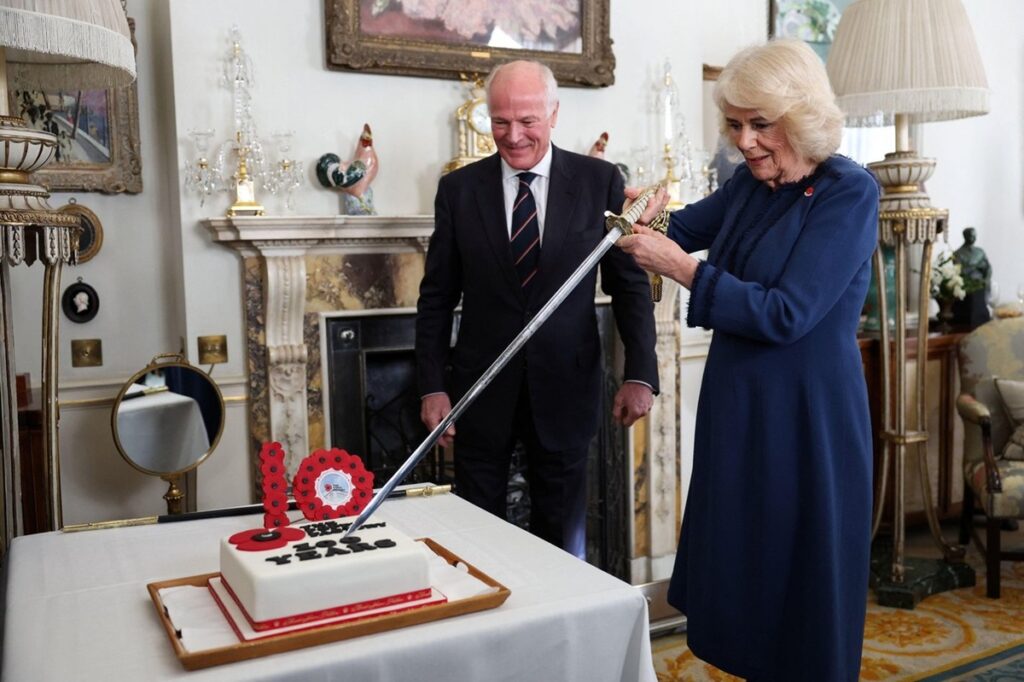 Regina Camilla în timp ce taie un tort cu o sabie