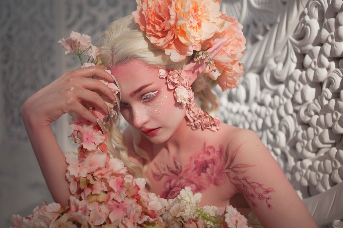 O femeie frumoasă care are părul alb și poartă flori ilustrând una dintre cele trei zodii ghinioniste în luna februarie 2024