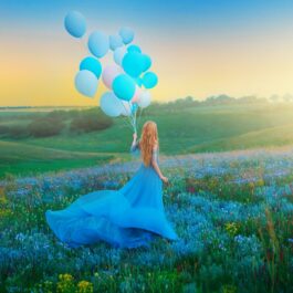 O femeie frumoasă care poartă o rochie albastră și ține în mână mai multe baloane, ilustrând totodată una dintre cele trei zodii independente în anul 2024