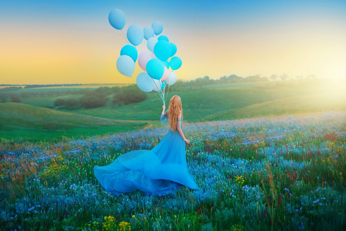 O femeie frumoasă care poartă o rochie albastră și ține în mână mai multe baloane, ilustrând totodată una dintre cele trei zodii independente în anul 2024
