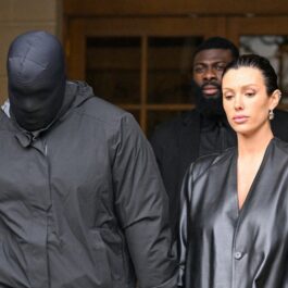 Kanye West acoperit pe față cu o cagulă alături de Bianca Censori, într-un palton din piele