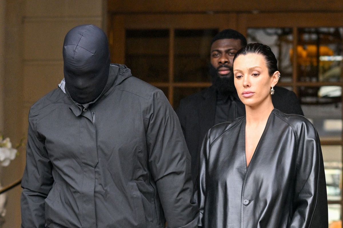 Kanye West acoperit pe față cu o cagulă alături de Bianca Censori, într-un palton din piele