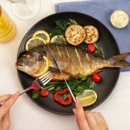 O femeie care consumă pește pentru a ilustra ce este dieta atlantică