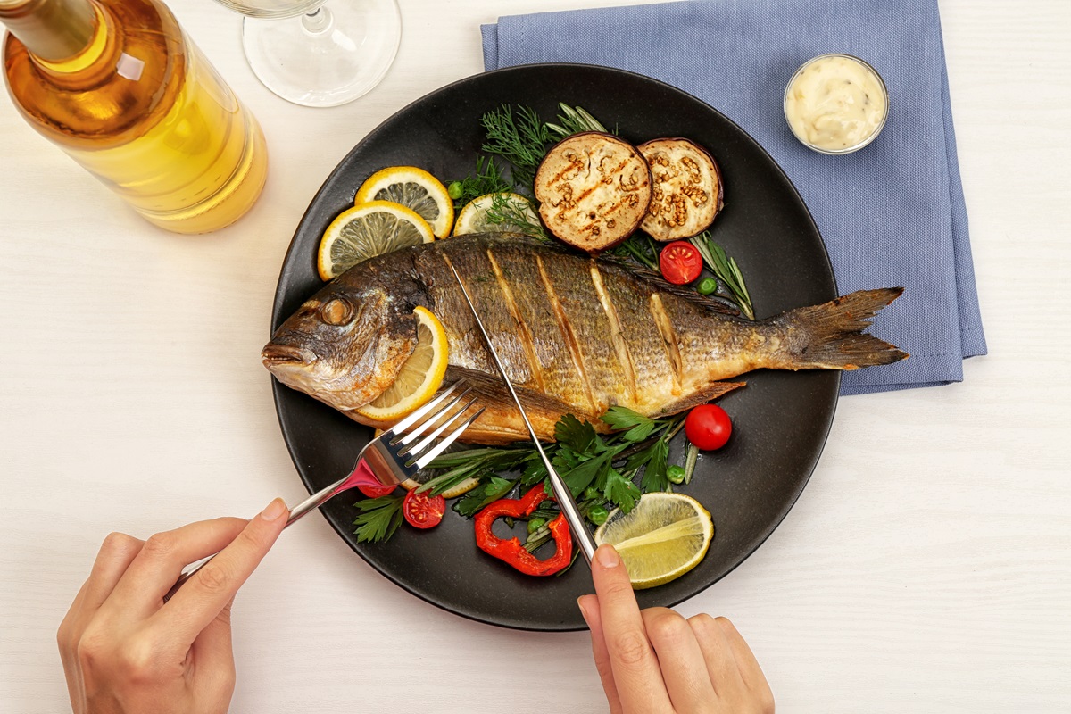O femeie care consumă pește pentru a ilustra ce este dieta atlantică