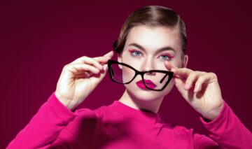 O femeie cu ochelari de vedere și machiaj roz