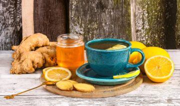 o cană cu ceai de portocale alături de câteva rădăcini de ghimbir și un borcan cu miere pentru a ilustra care sunt cele mai bune ceaiuri pentru sănătate